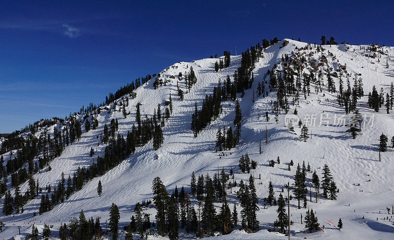 山峰和山峰映衬着模糊的冬日天空。Palisades Tahoe滑雪胜地，加利福尼亚。